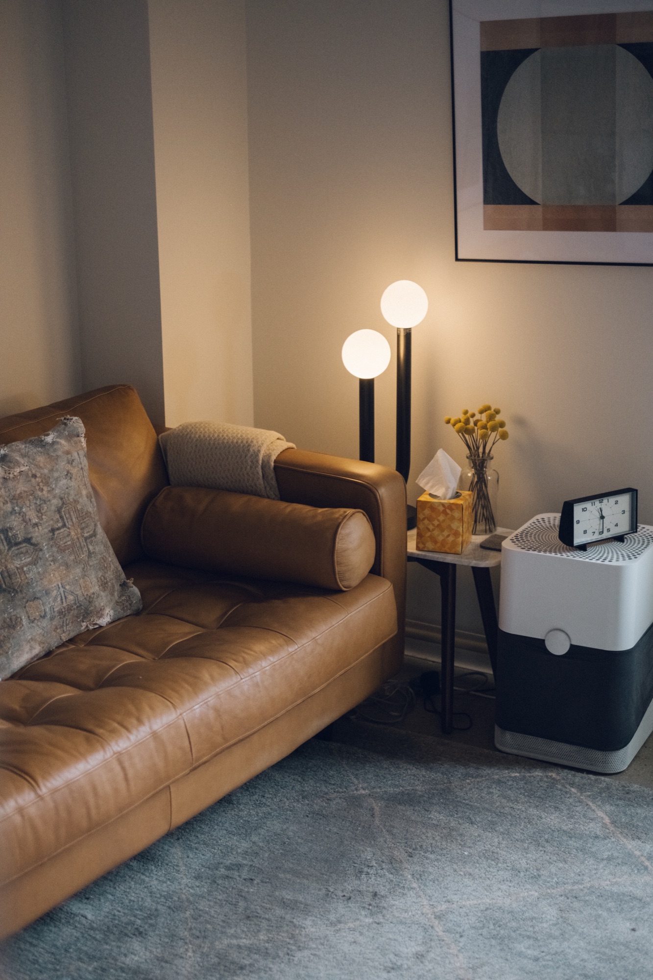 A leather couch beside warm lamps in a therapy office.